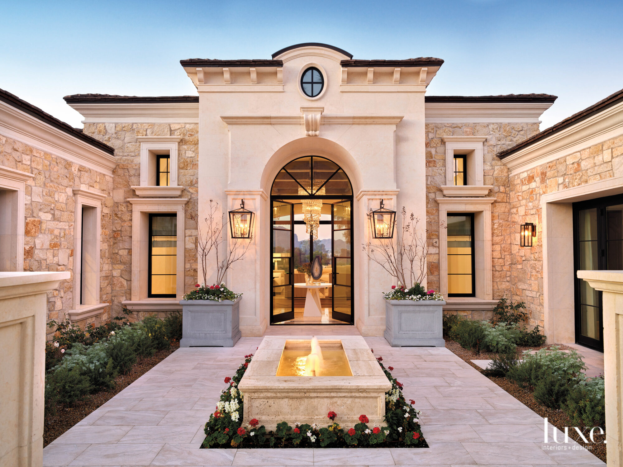 The dramatic entry of this Mediterranean-style home has a custom entry chandelier.