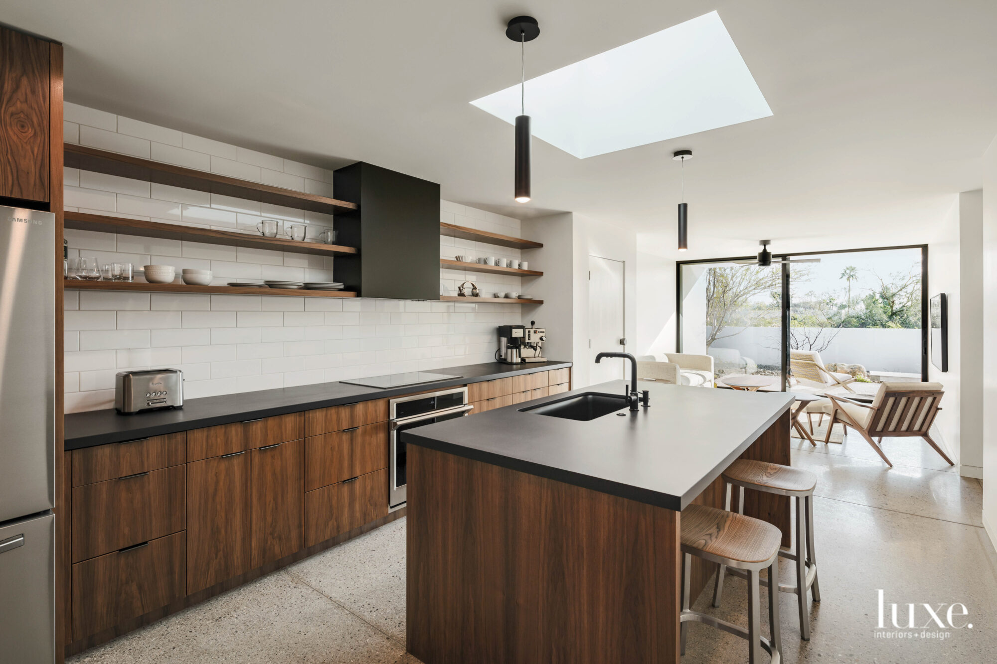 The guesthouse kitchen has matte black countertops with wood bases.