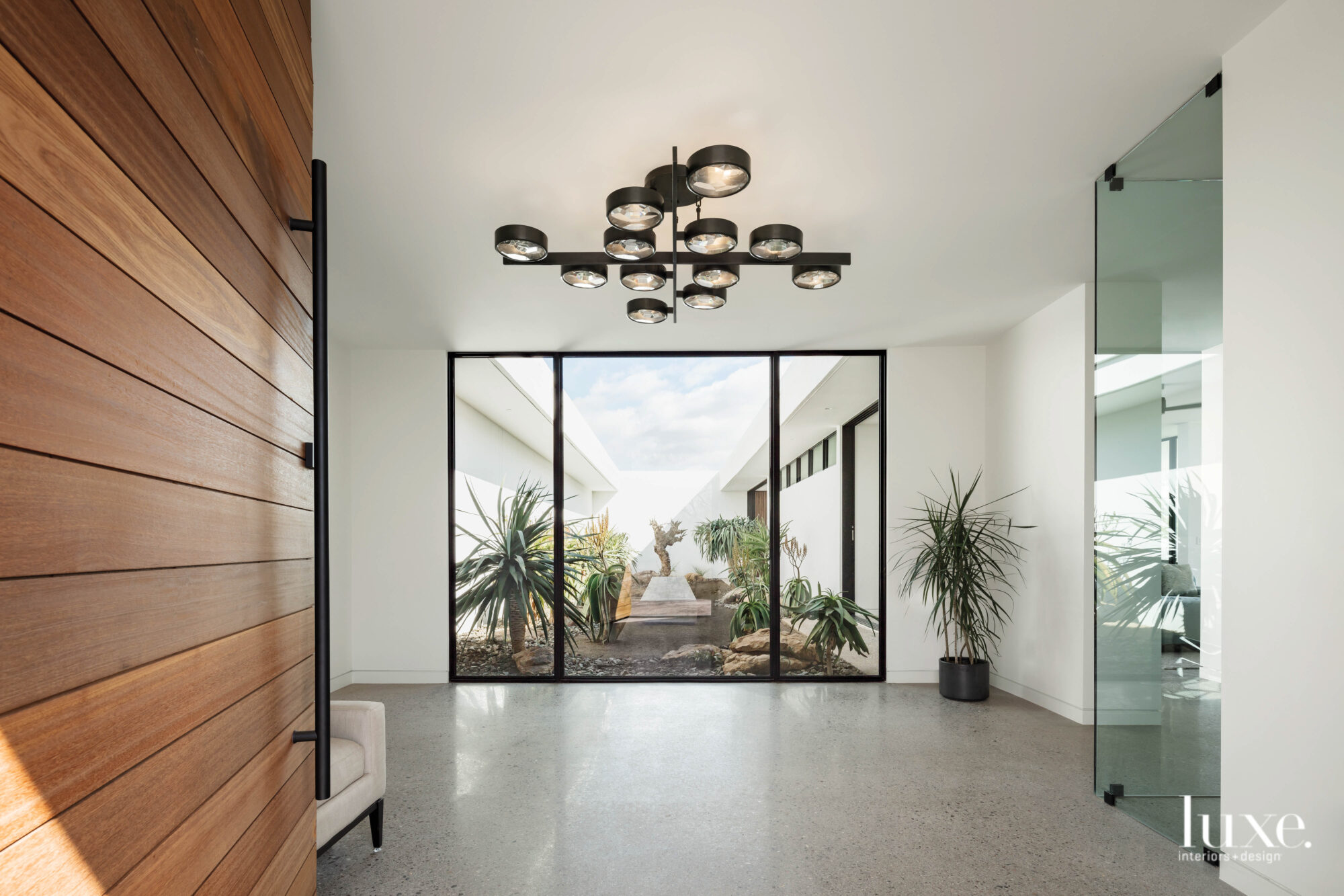 The minimalist entryway with concrete floors that looks into a courtyard.