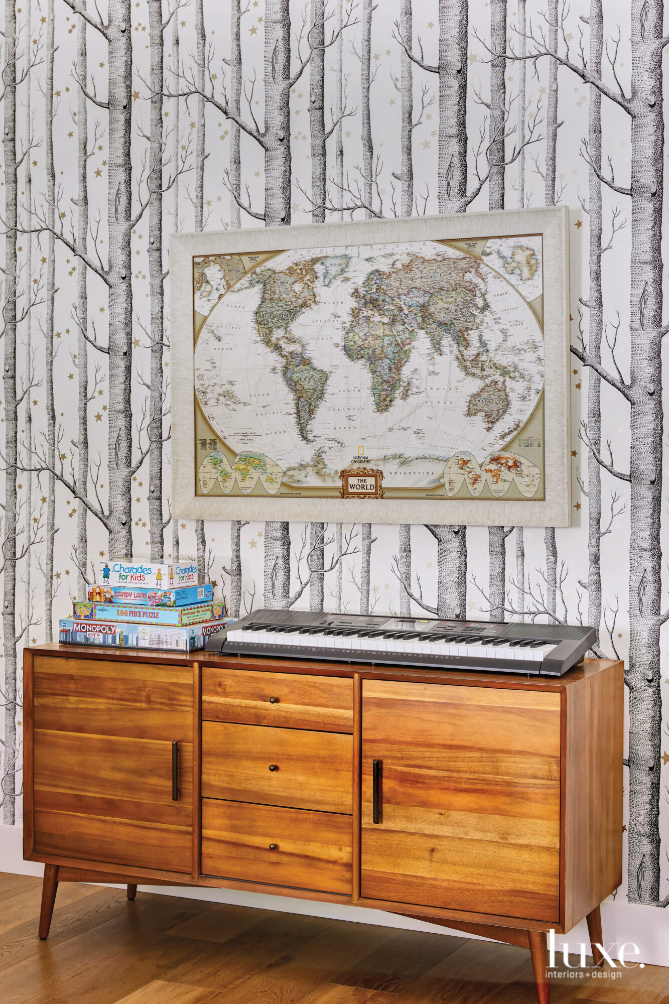 In the kids' play room hangs illustrated wooded wallpaper and a map of the world.