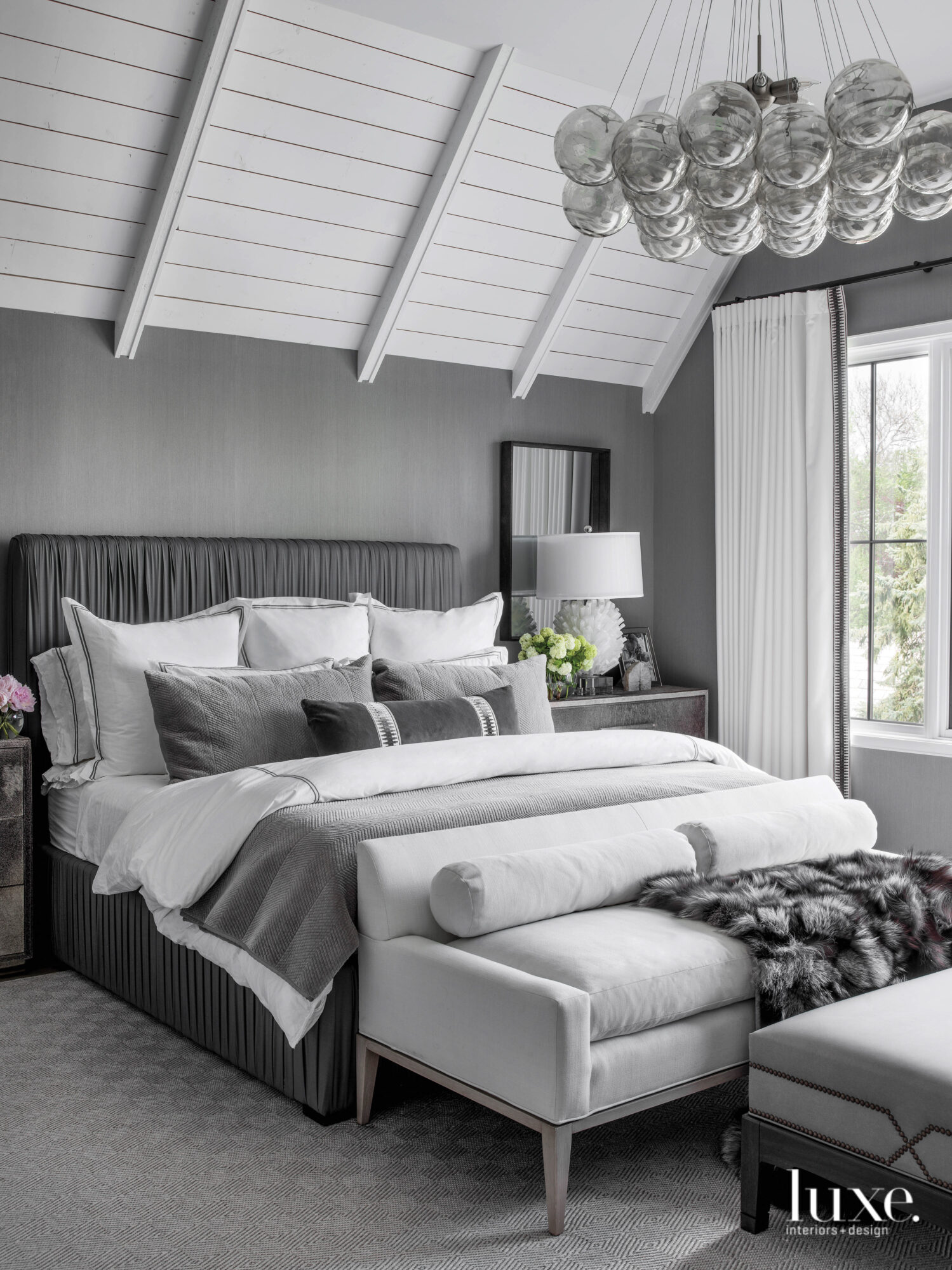 The clients' bedroom is done in shades of gray, including an upholstered sateen bed.