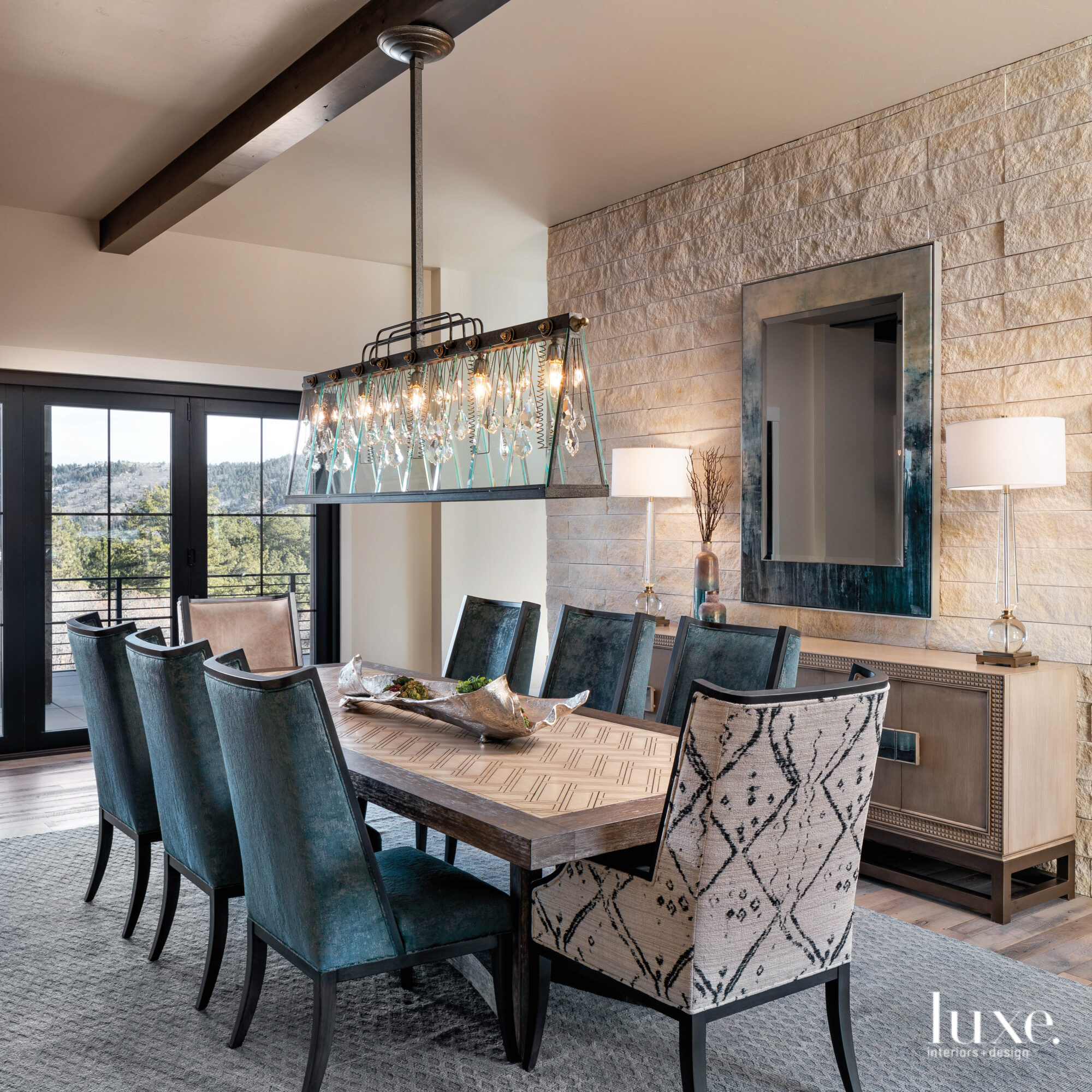 The dining room has a long table and a linear chandelier.
