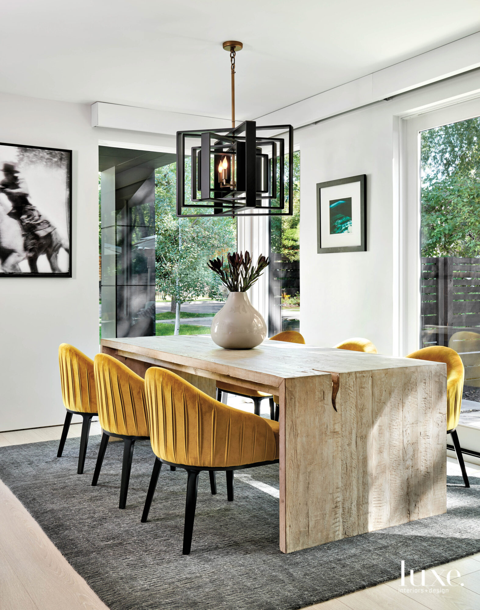 A dining room features mustard-colored chairs and a modern light fixture.