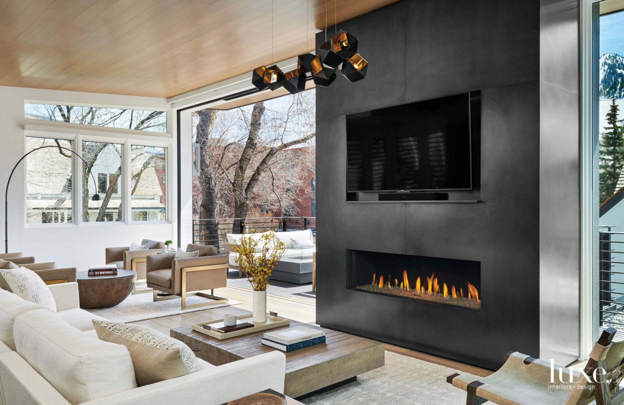 In the living room, a fireplace is surrounded by steel, a large sliding door opens to the outside.