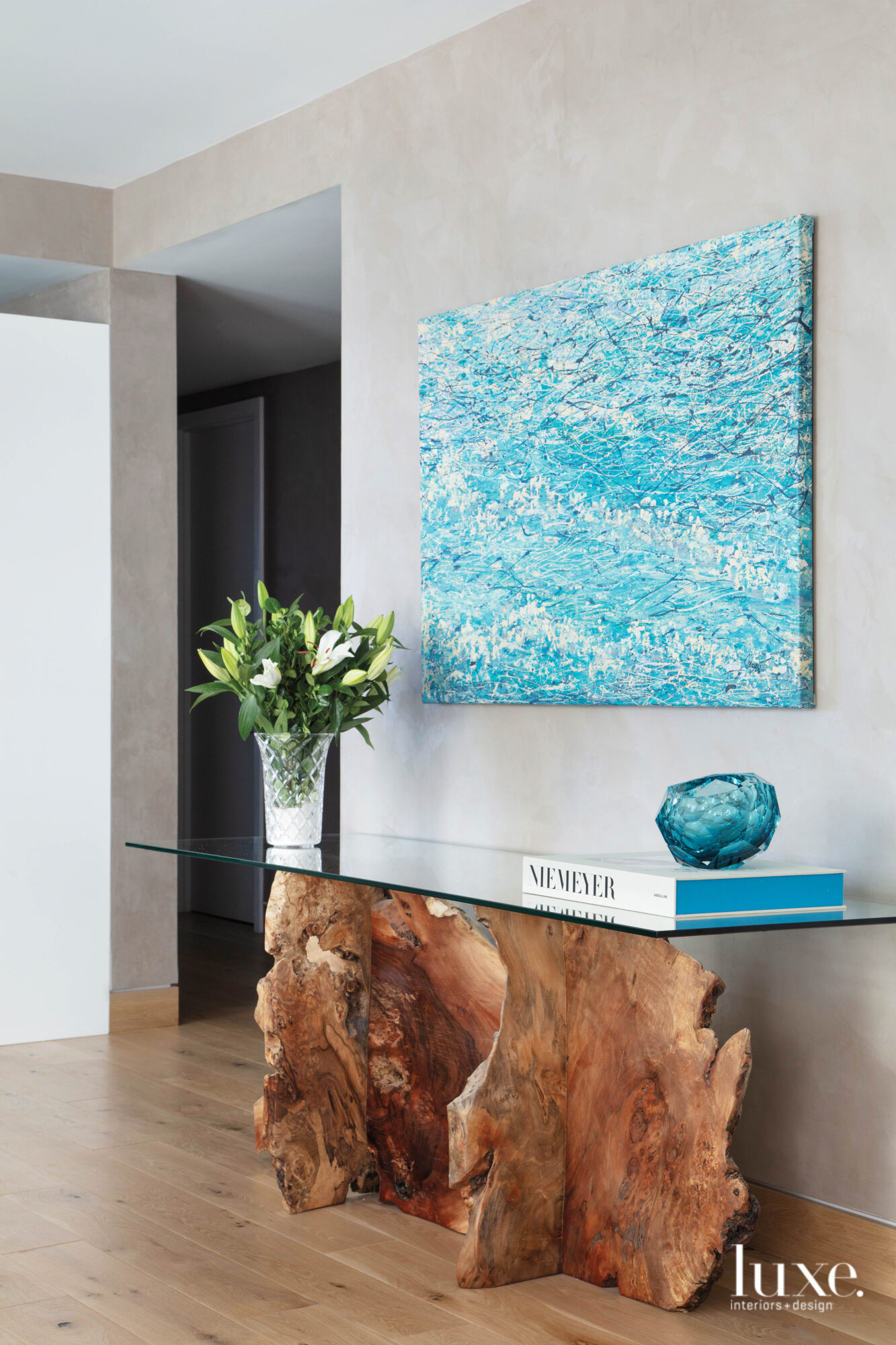 hallway with blue oil painting and wood console table