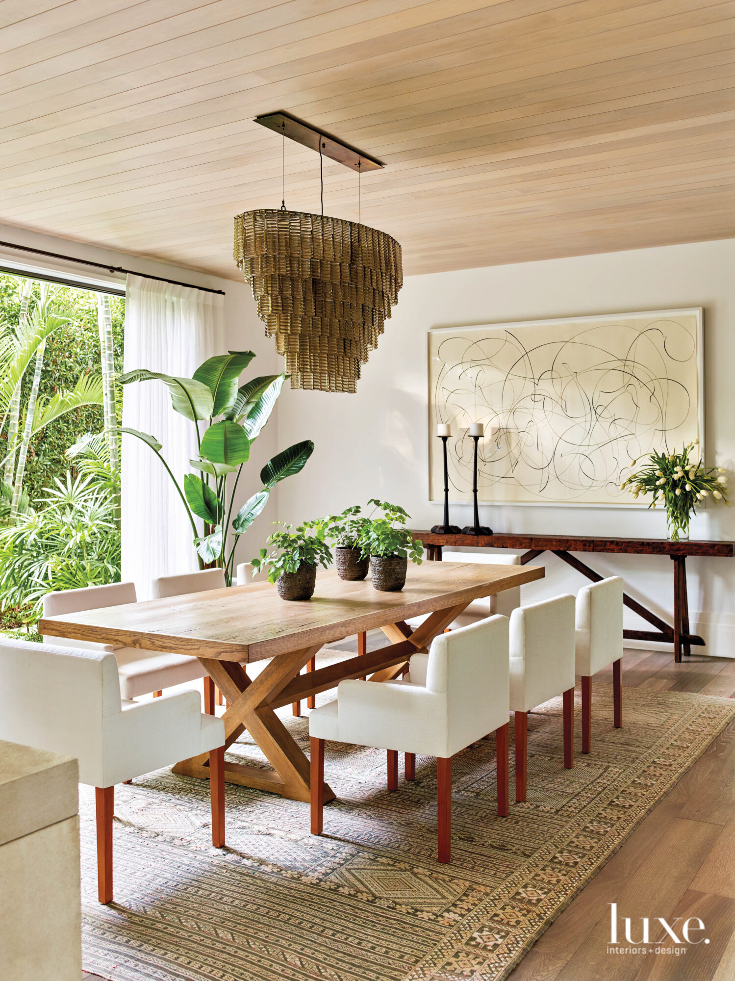 dining area with wood table, white chairs and Murano chandelier