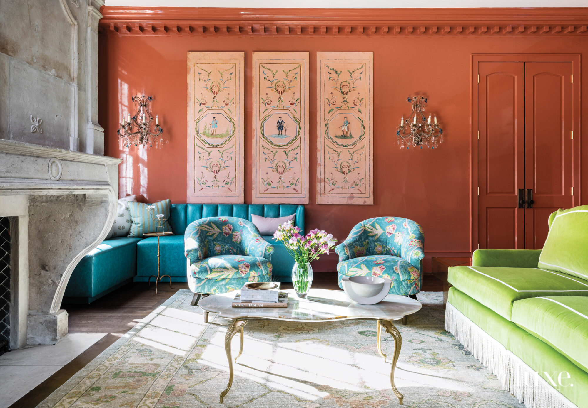 Living room with bright terra cotta walls and furnishings and statement art