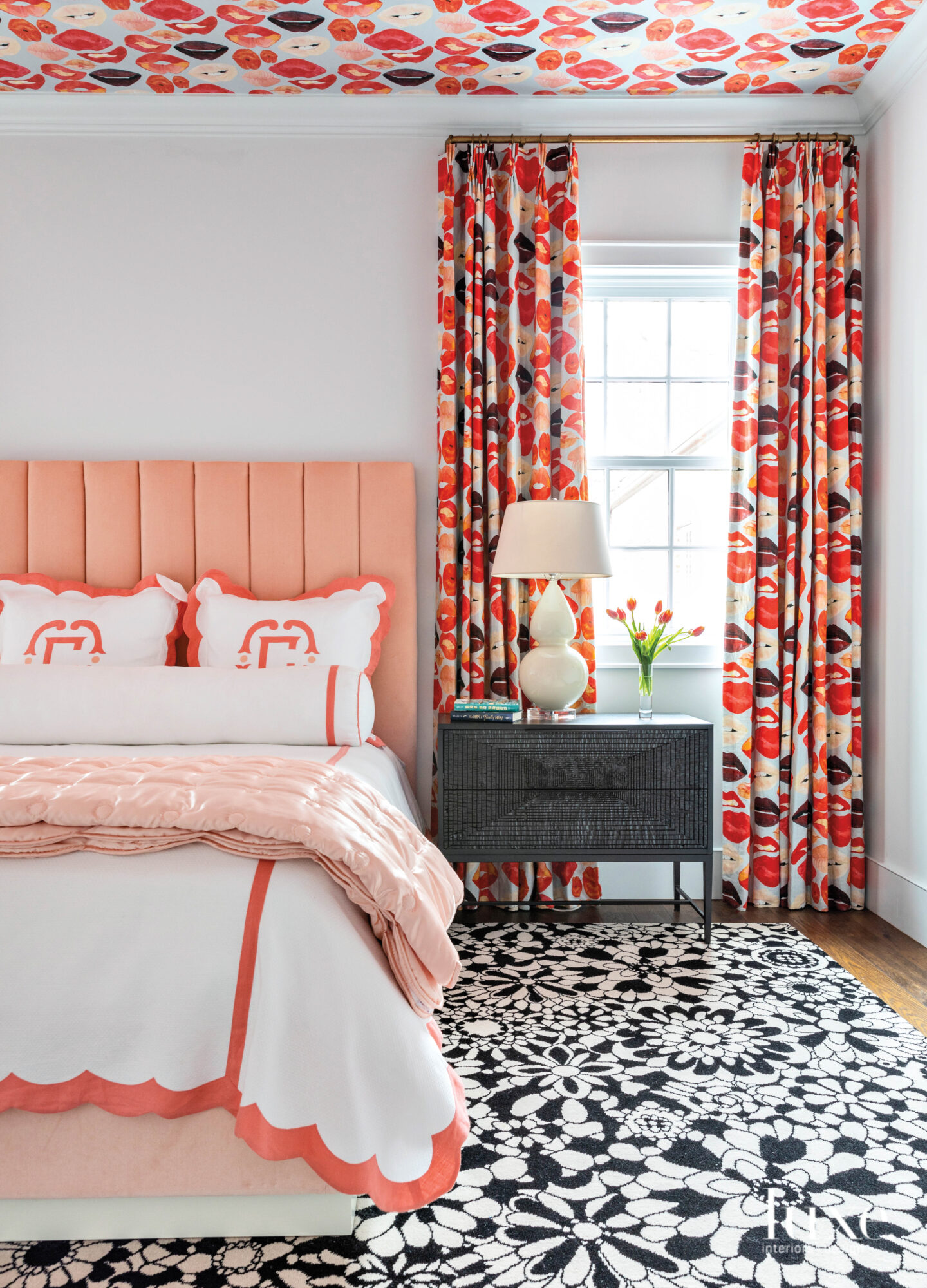 bedroom with peach bed and headboard and patterned drapes