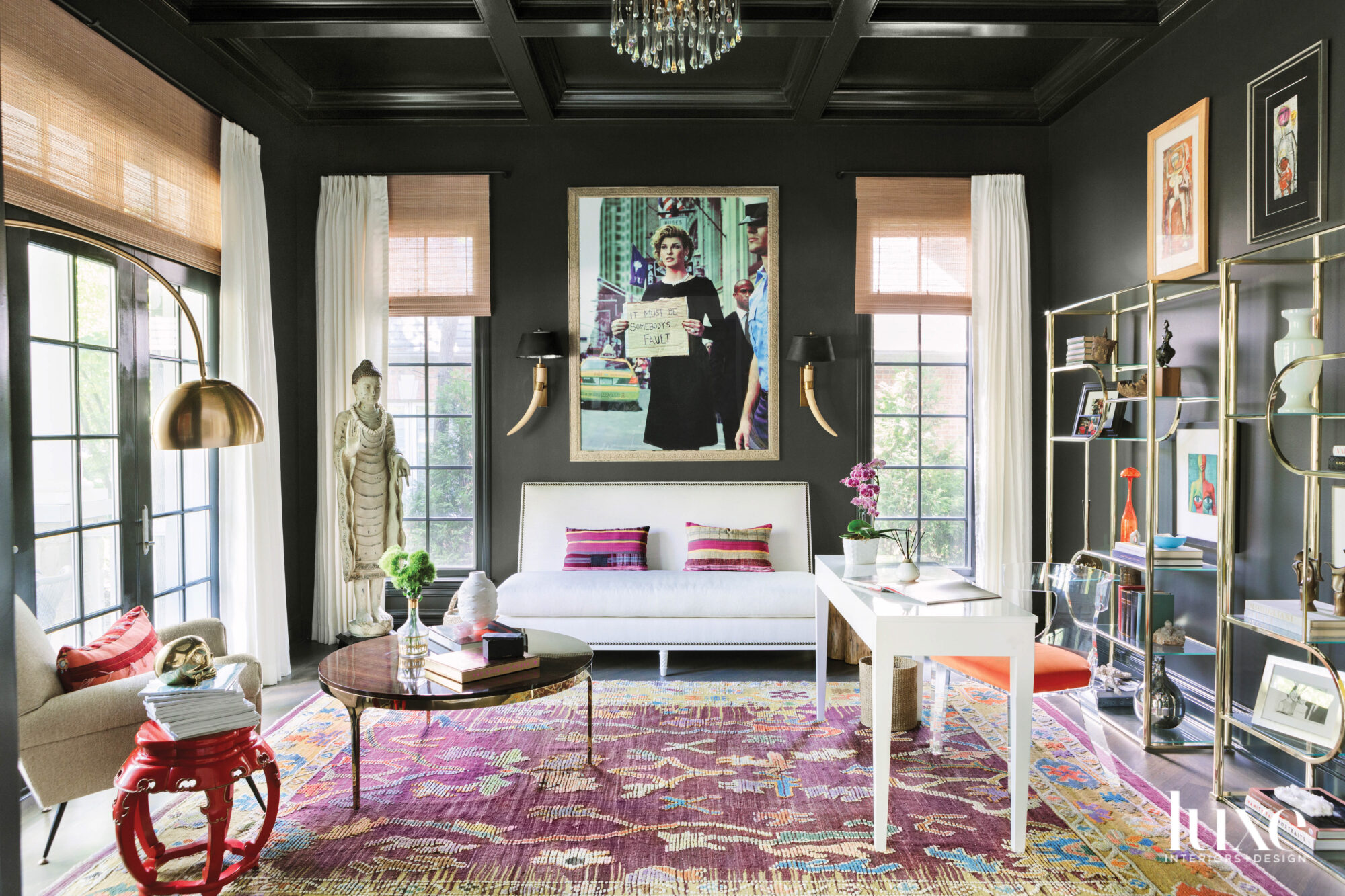 An office with black walls and a pink-and-gold rug.