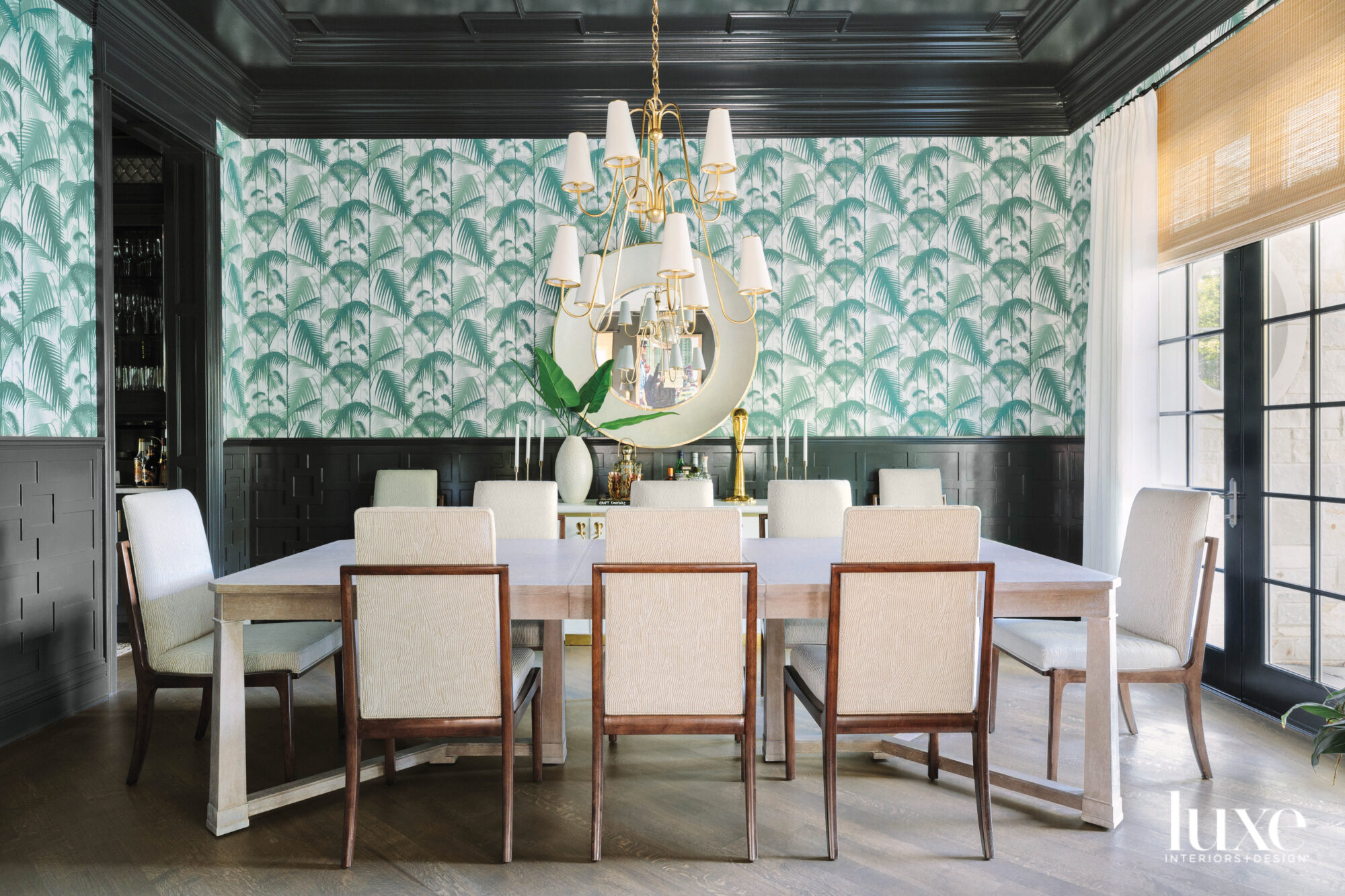 A dining room with palm print wallpaper.
