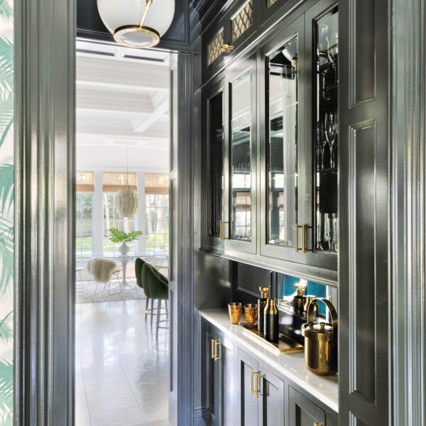 Bold Colors And Funky Furnishings Transform A Neutral Chicago Home A cocktail pantry painted in black. The cabinets have brass hardware.