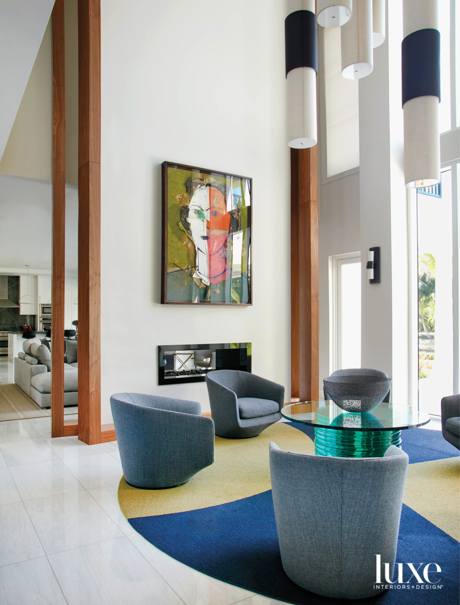 seating area with circular rug, six armchairs and colorful artwork