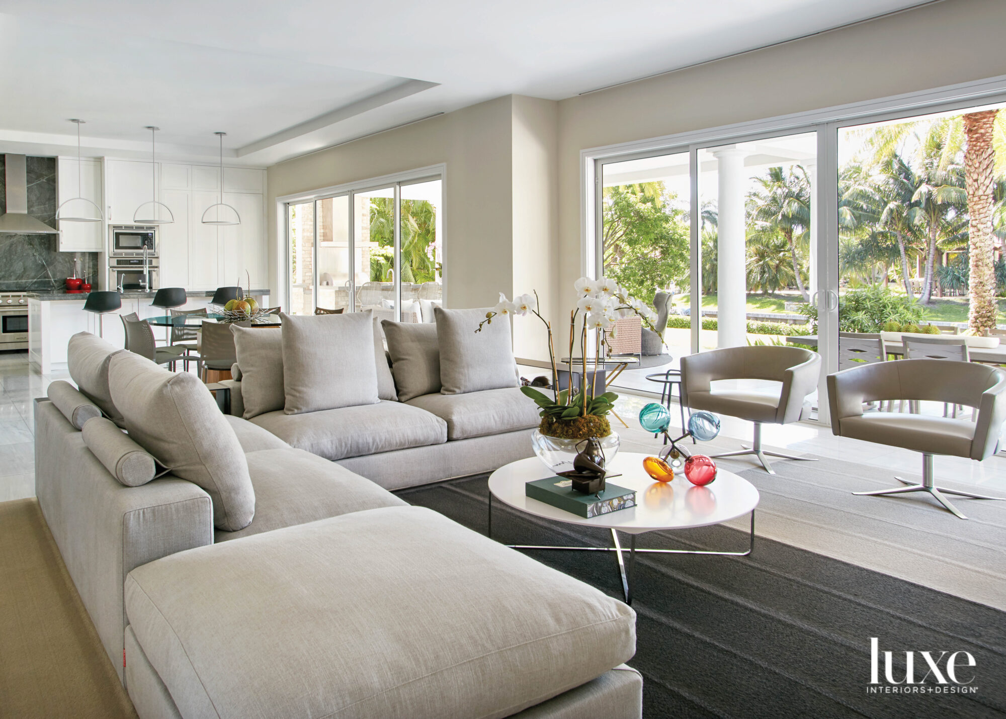 living area with tan sectional, round coffee table and dark gray rug