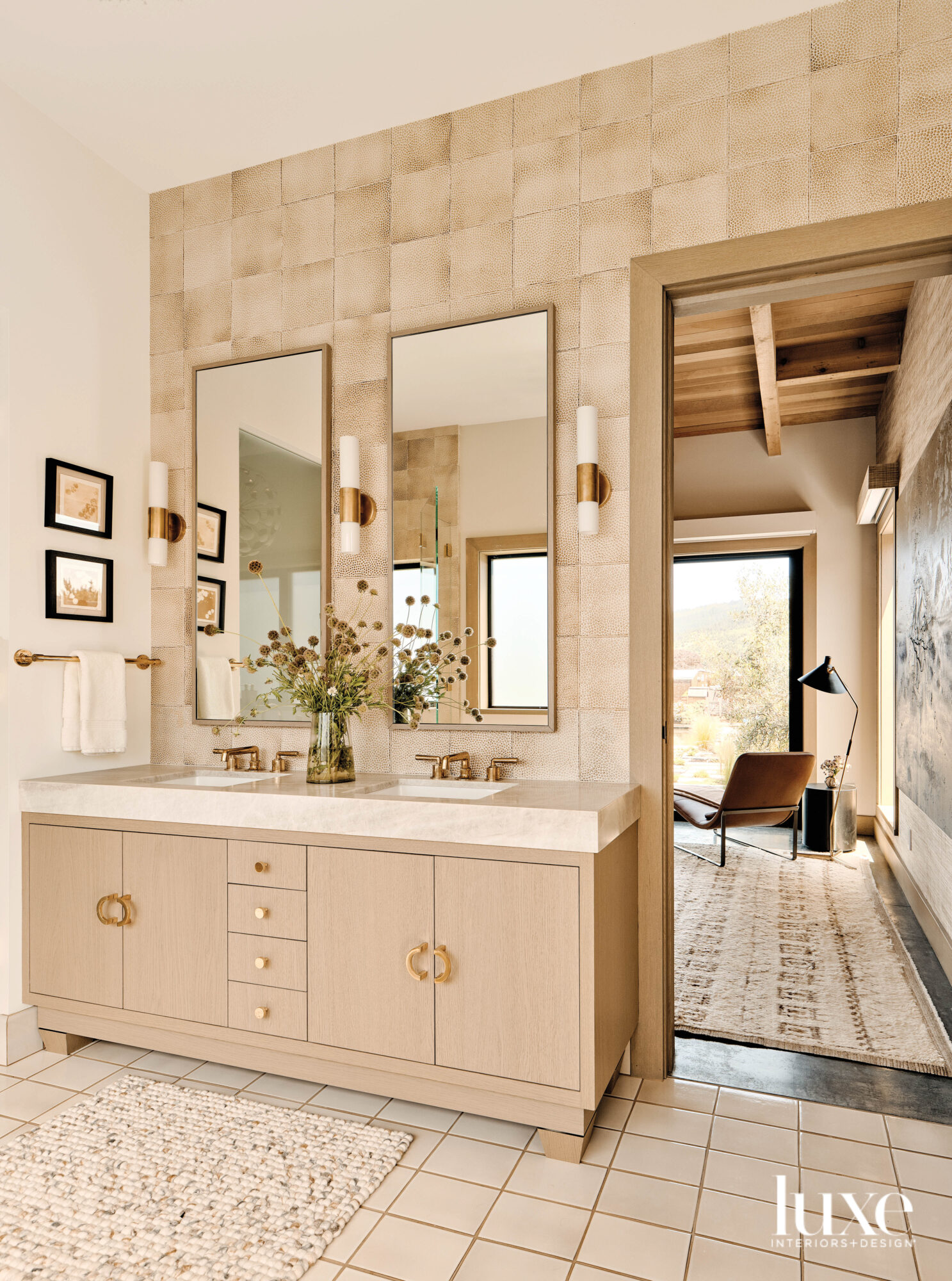 The primary bathroom has rustic tile and light-colored cabinets.