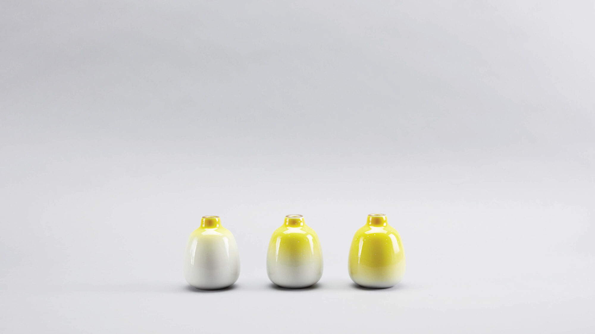 three white and yellow vases