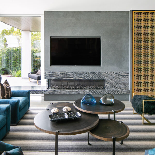 In Newport Beach, A Couple Brings Modern Edge Into Their 1960s Home gray great room stone fireplace