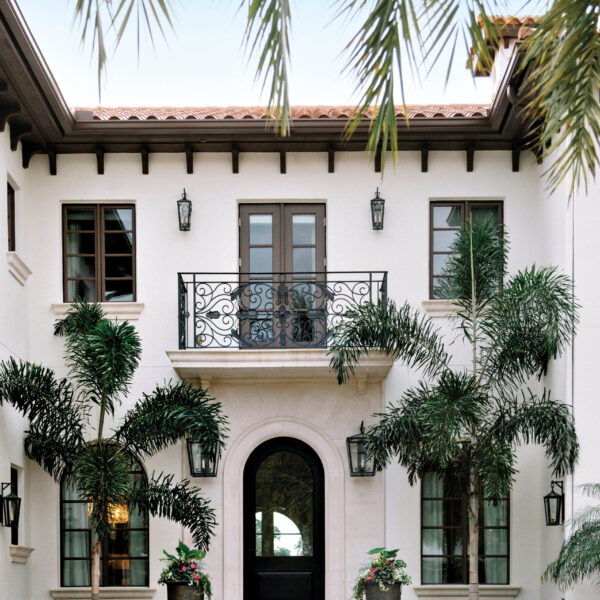 A Mediterranean-Style Florida Home Gets A Southern Overhaul Mediterranean-style exterior of home with entrance framed by palms.