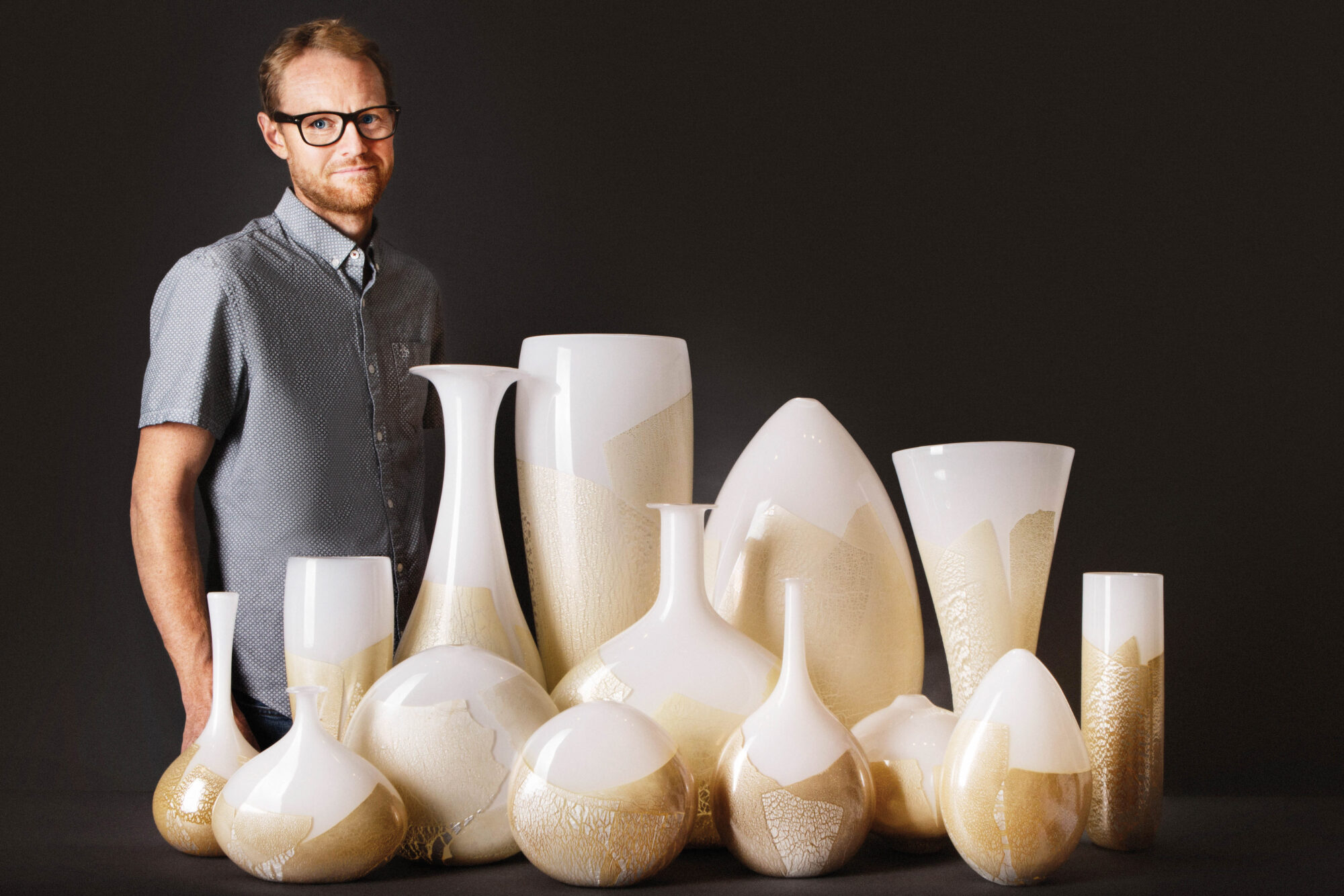 Glass artist with cream-colored vases
