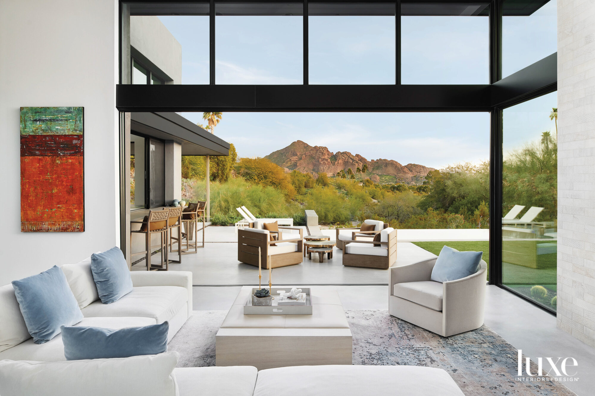A living room with retractable floor-to-ceiling windows that open out to a patio.