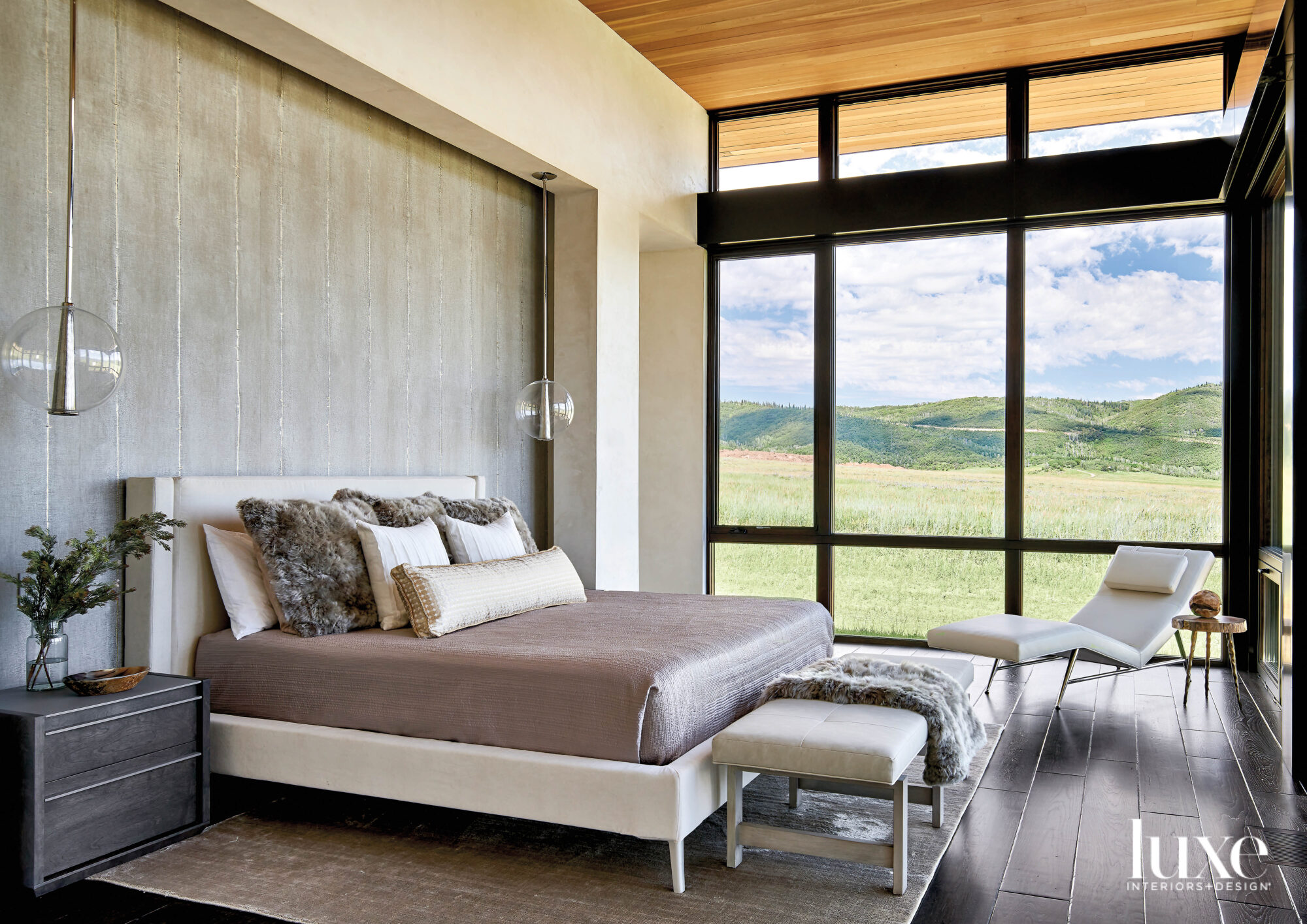 A white bed frame contrasts against grey gold-leaf wallcovering.