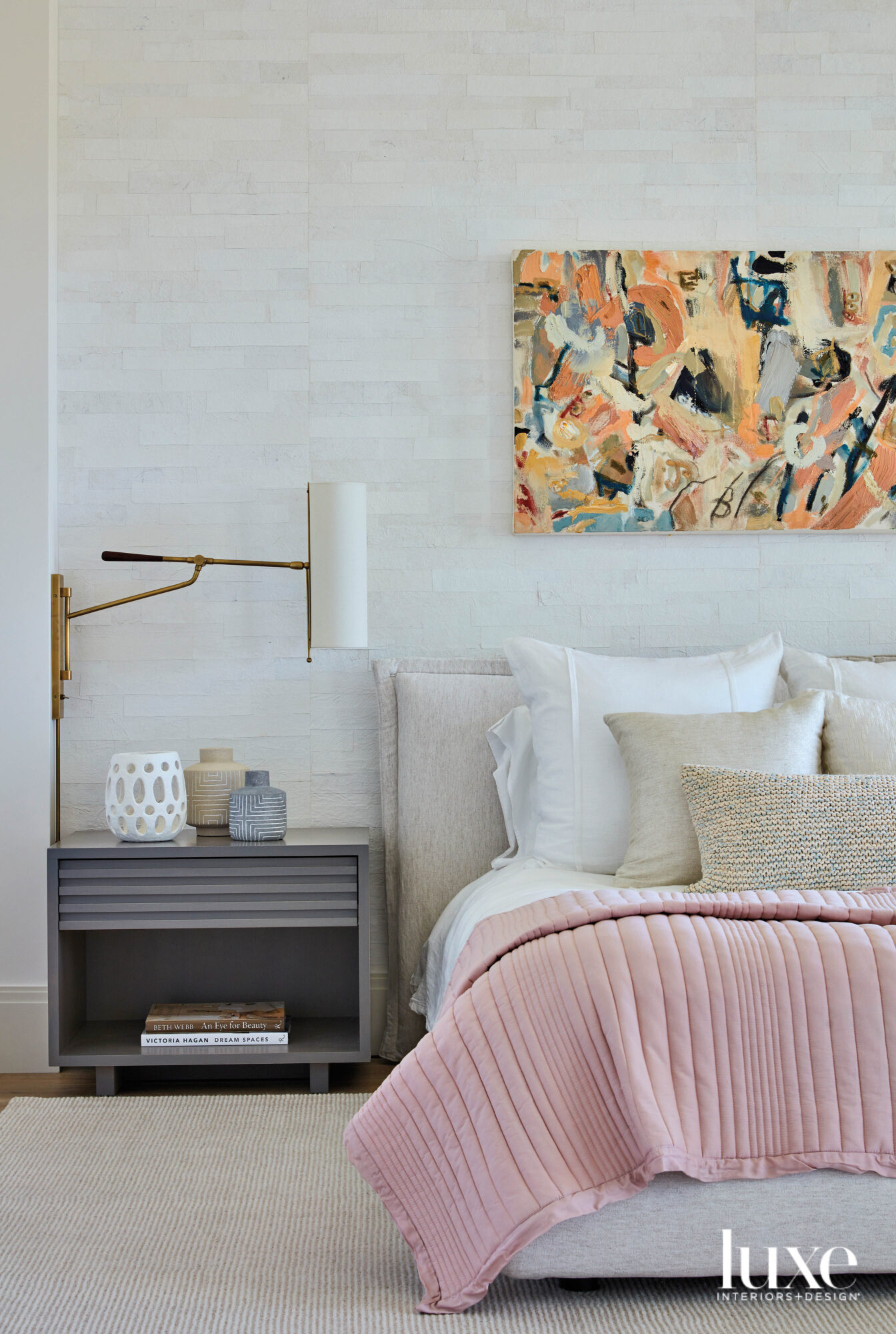 bedroom with pink bed, gray nightstand and vibrant watercolor art