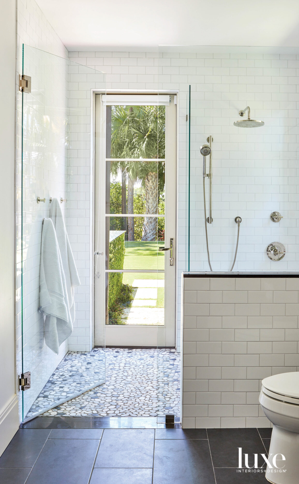 bathroom with light blue tile that leads to outdoors