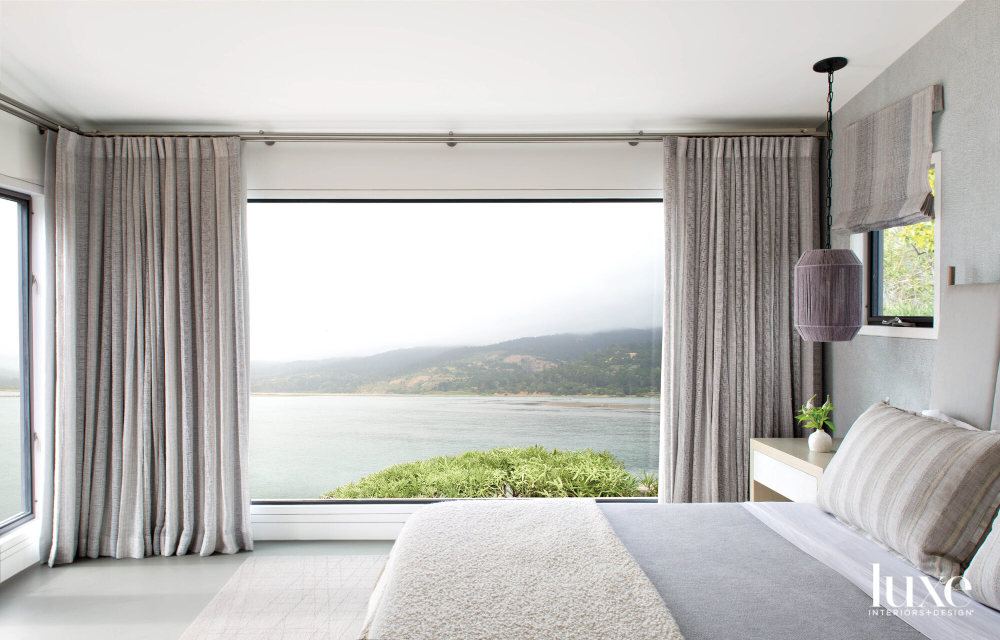 main bedroom with white bed and water view
