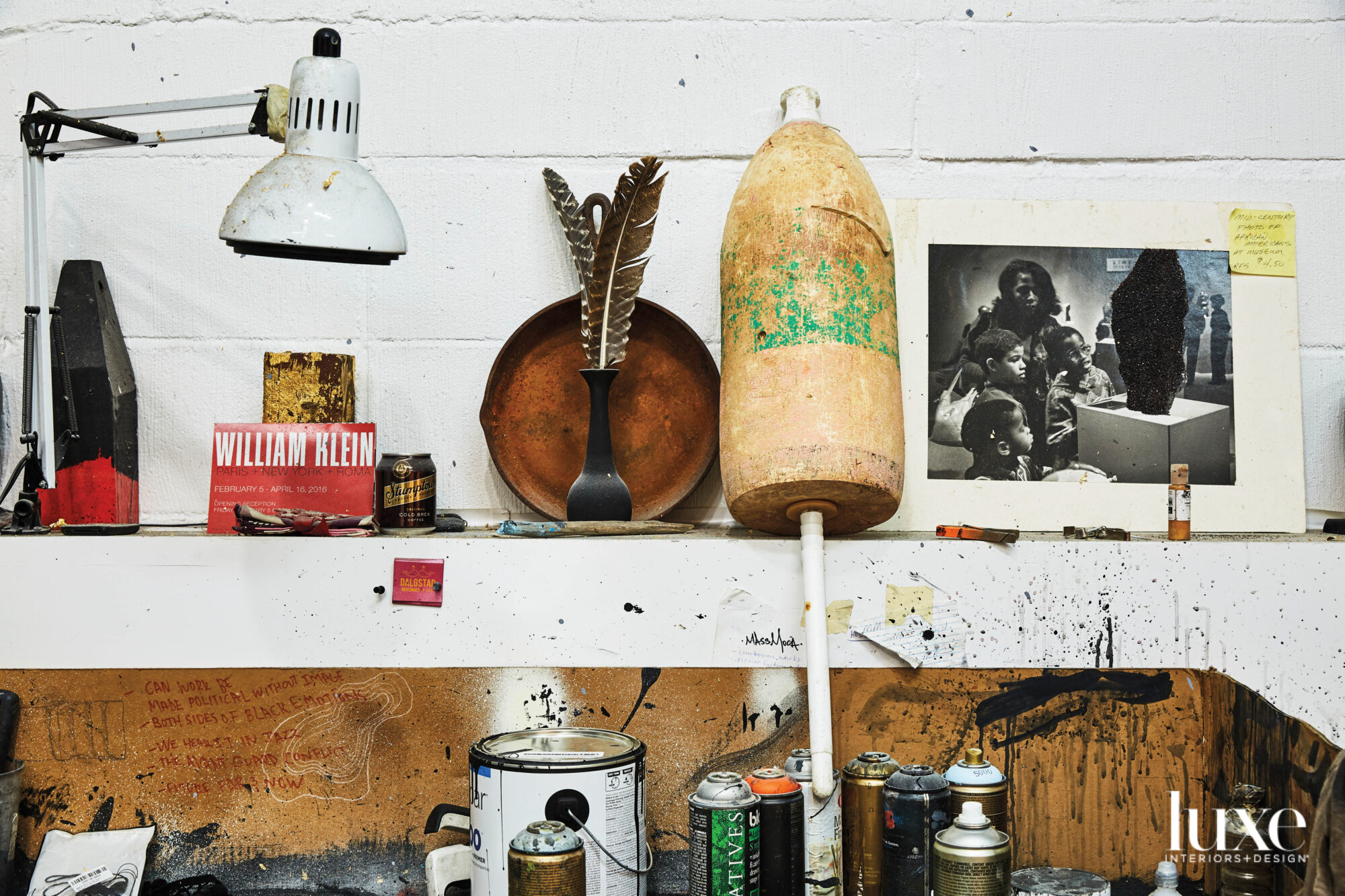 Paint-splattered shelf with paint cans, objects and ephemera
