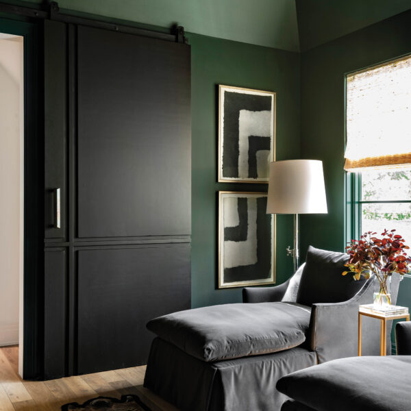 It’s Back To Basics At A Houston Haven That Elevates The Essentials Cozy media room with green walls and black barn doors.