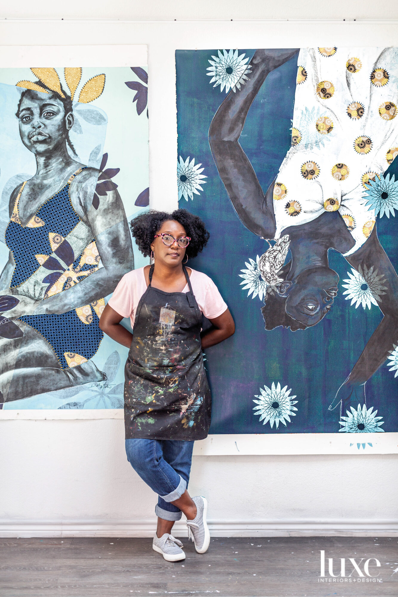 Artist Delita Martin posing in front of her mixed-media prints.