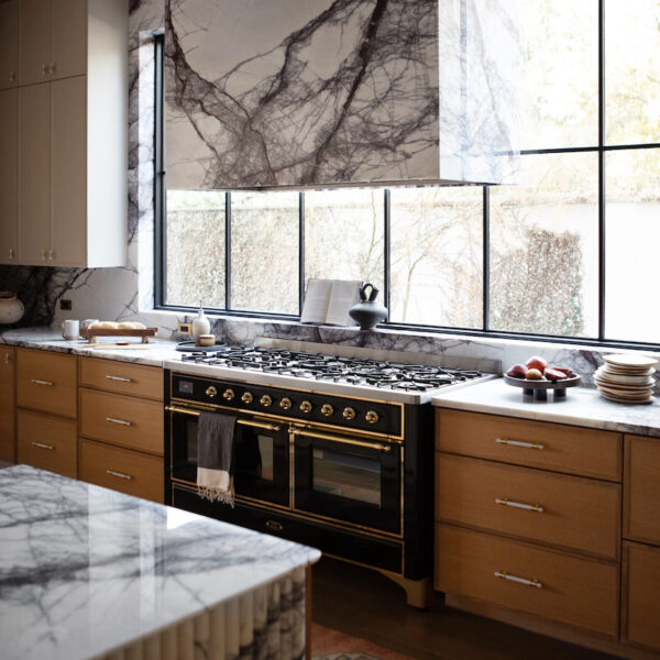 Sleek kitchen design with marble counter tops and a panoramic window for a bright atmosphere.