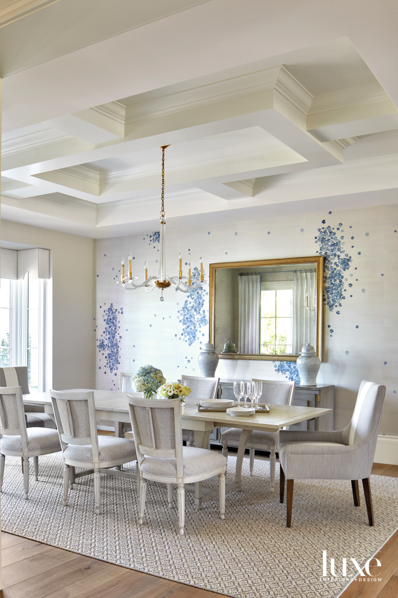 A dining room with a blue floral wallcovering.