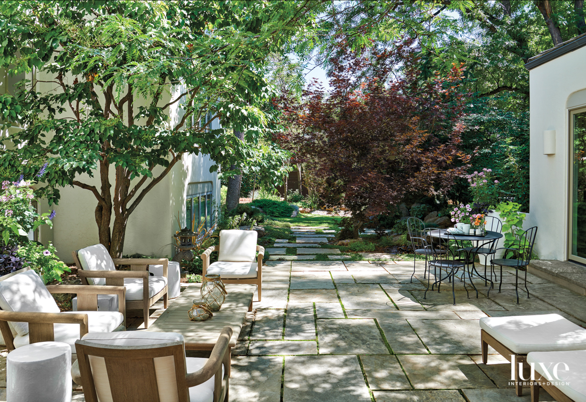 A lush courtyard filled with white cushioned chairs serves as garden inspiration