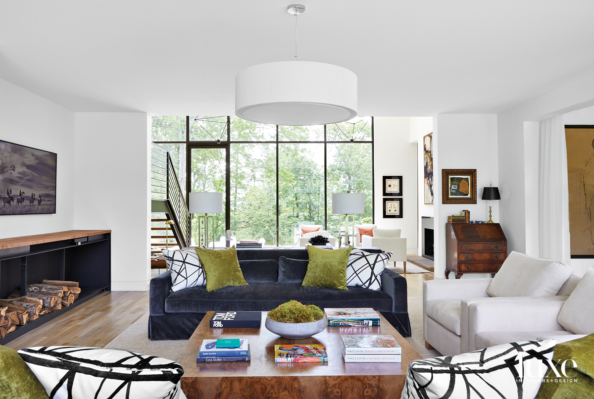 Living room with charcoal gray sofa, burl wood coffee table, drum pendant ceiling fixture and floor-to-ceiling windows