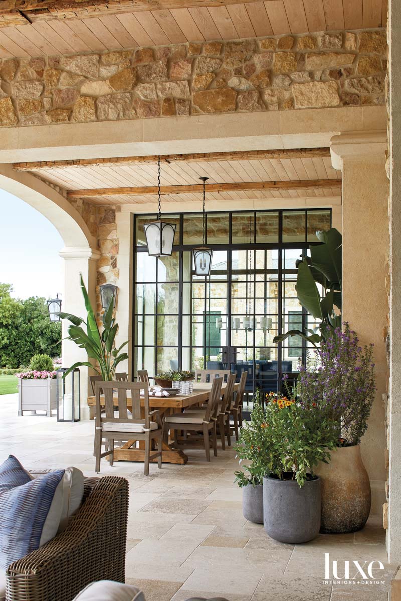An outdoor dining room with plants throughout the space.