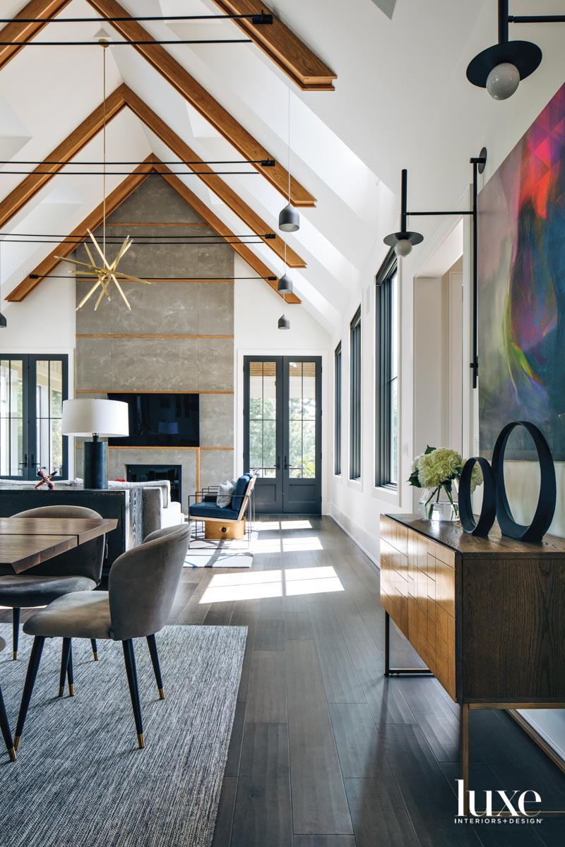 A great room with wooden ceiling beams and a concrete fireplace.