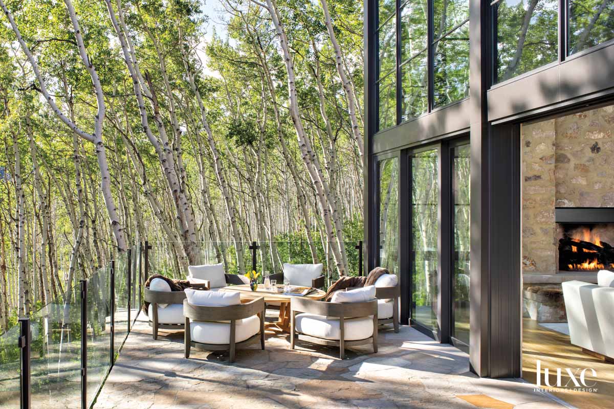 A patio sits in front of a grove of aspen trees.