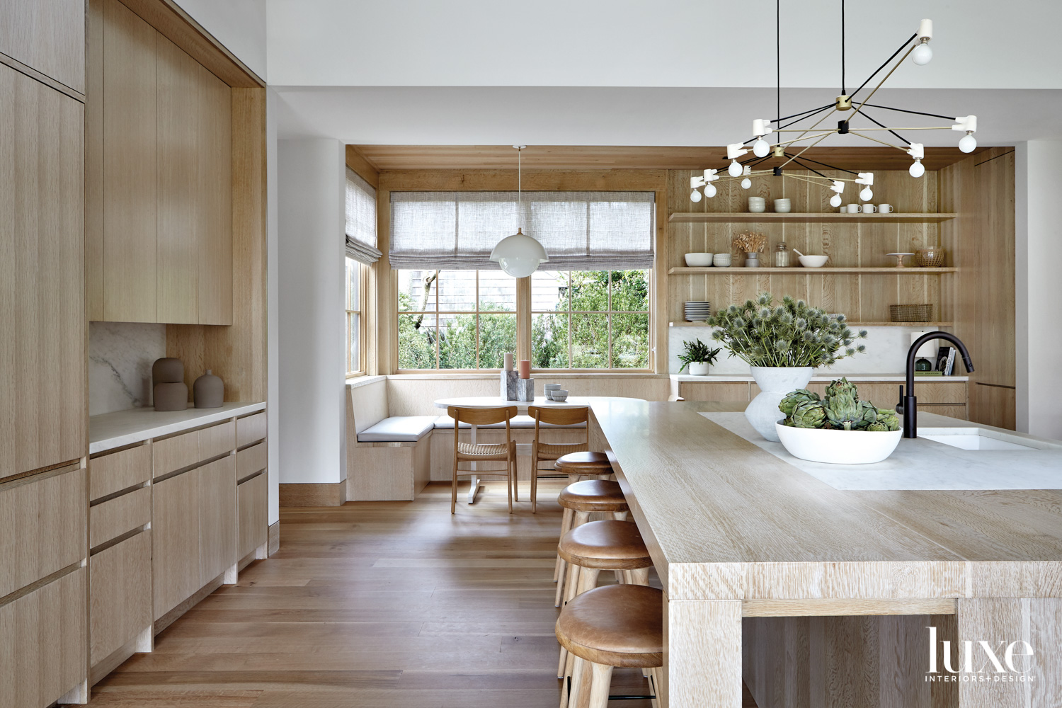 White oak island with bar stools in minimalist kitchen
