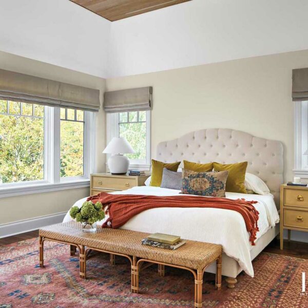 A Wilmette Home Delivers On A Wish For A More Laid-Back Lifestyle transitional bedroom brightened by a peachy-orange patterned rug under bed