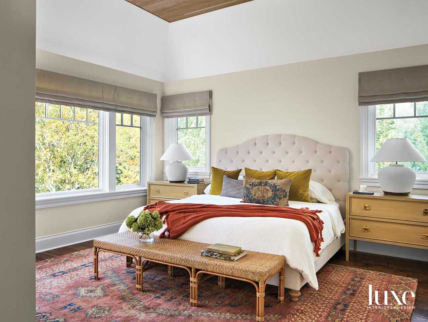 transitional bedroom brightened by a peachy-orange patterned rug under bed