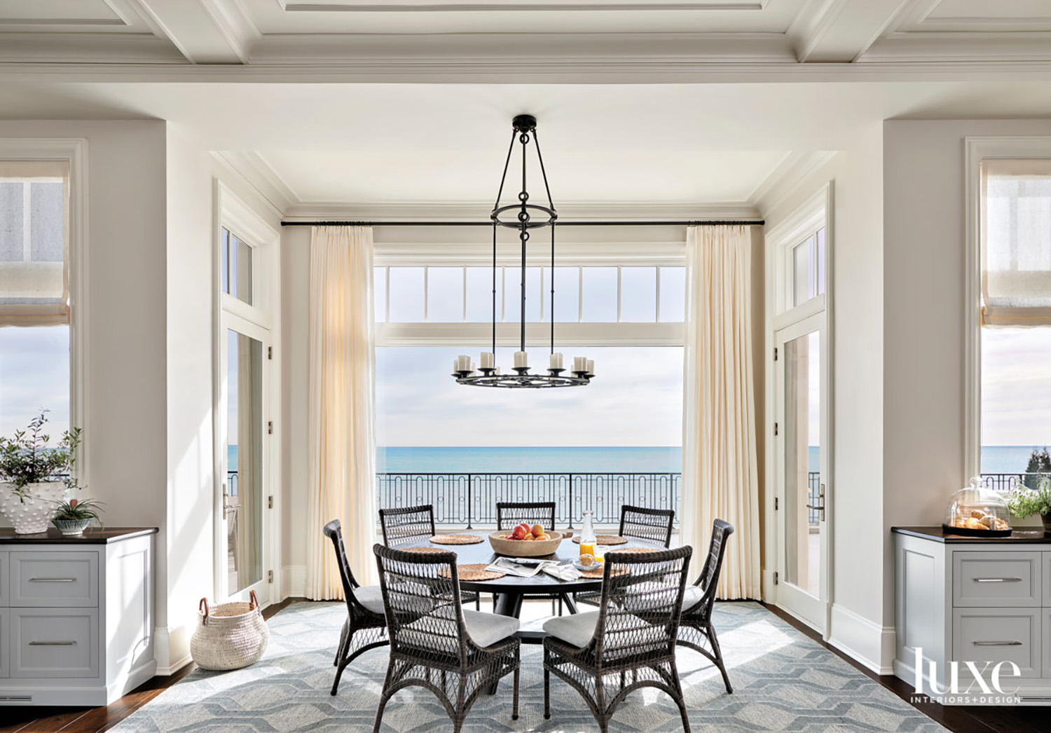 A round dining table surrounded by seven chairs that provide views out to the lake.