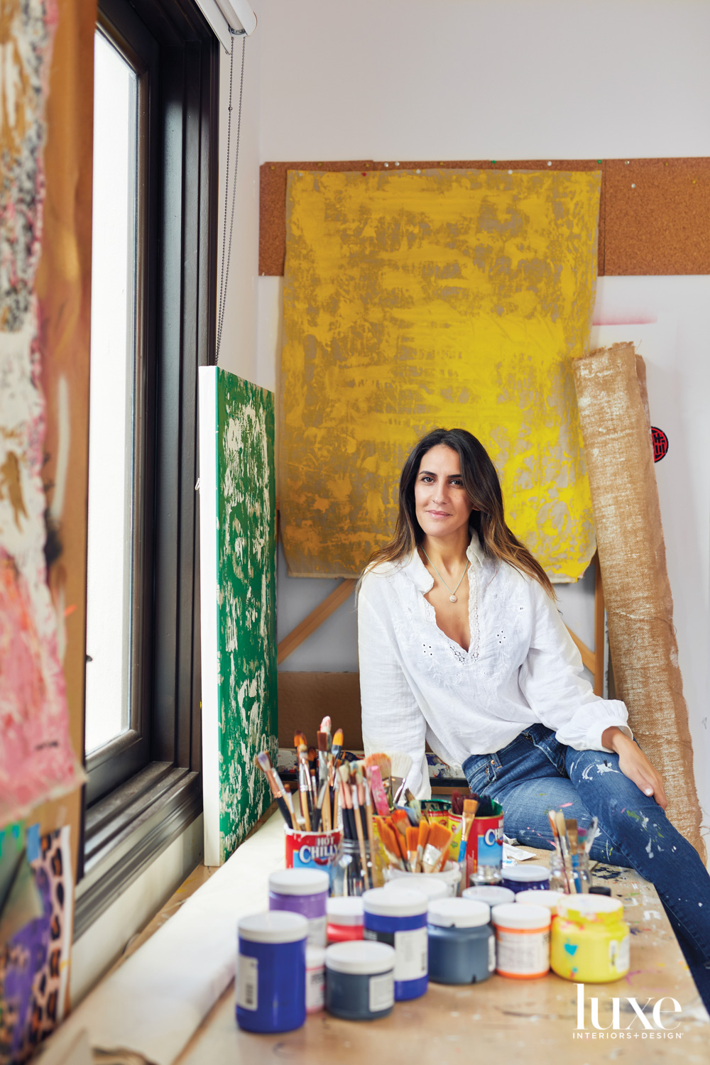 artist aidan marak surrounded by her artwork in her studio