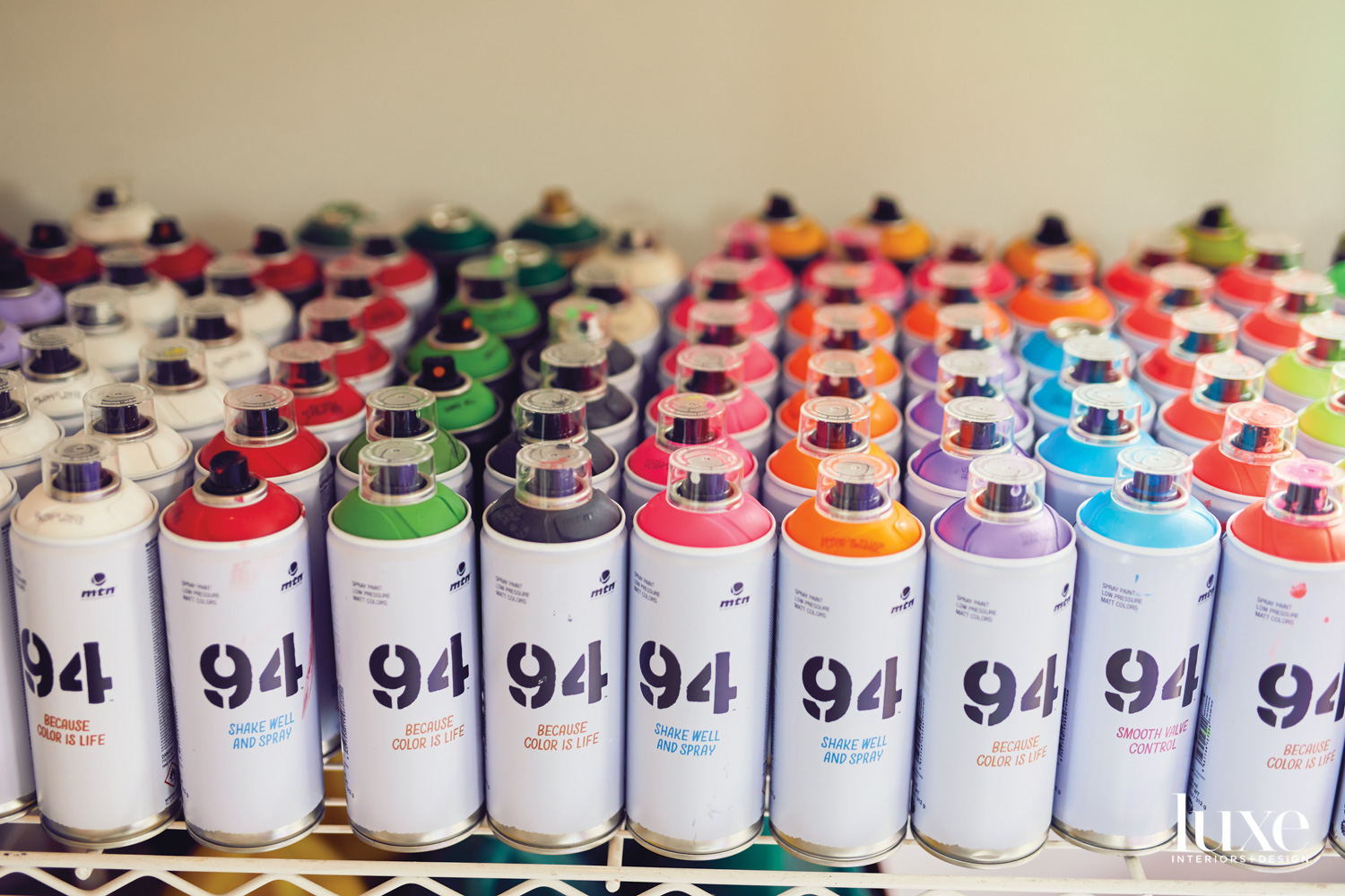 rows of paints on a shelf in aidan marak's studio