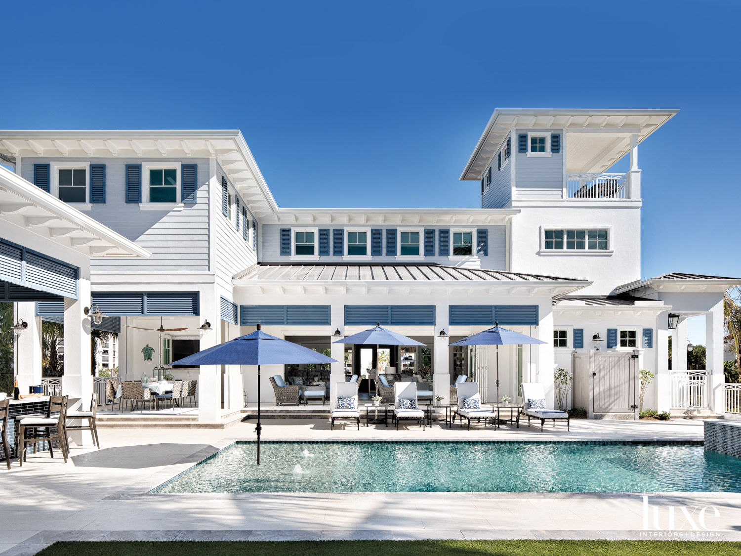 back pool area of two-story gray-and-blue residence