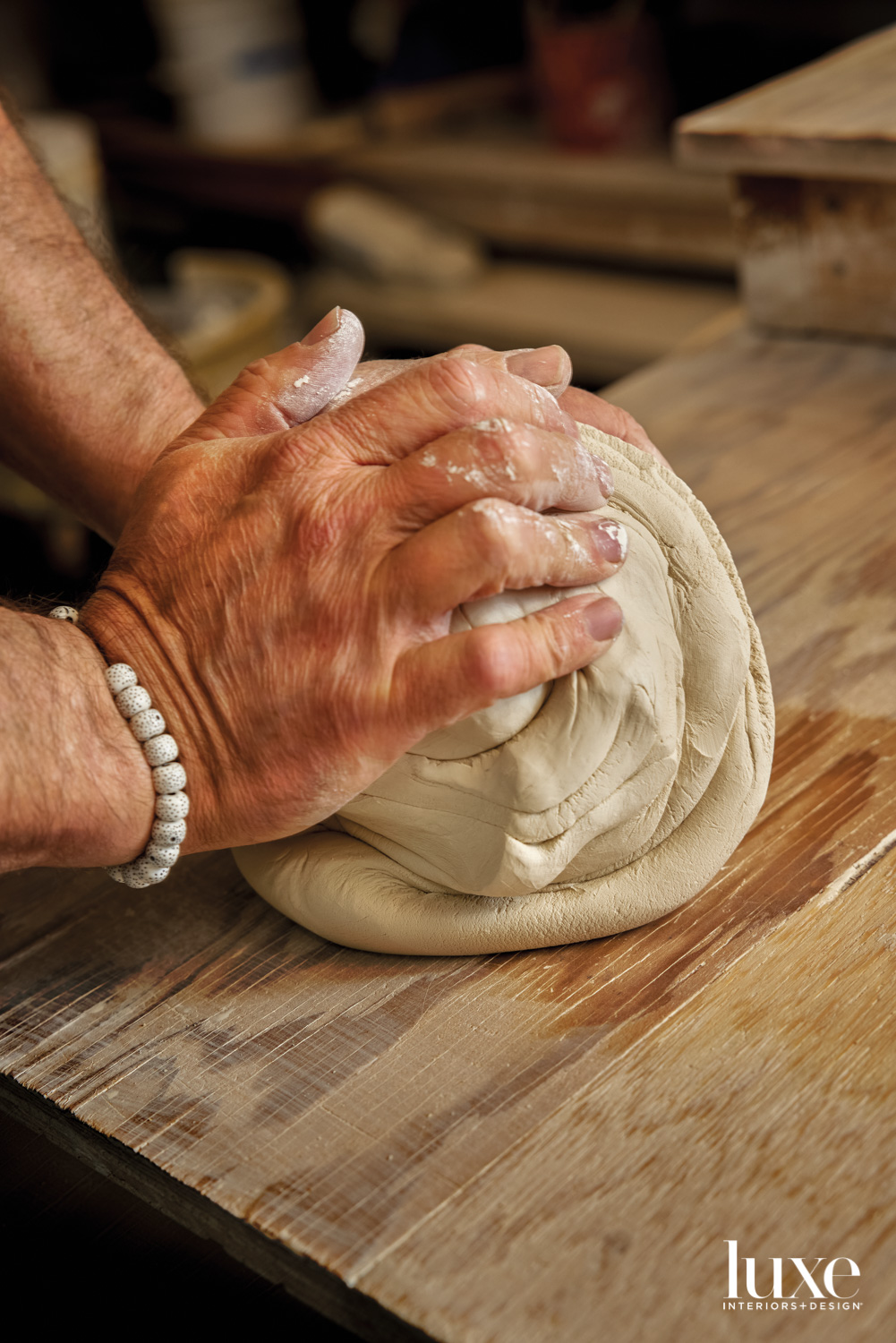 A pair of hands kneeding clay.