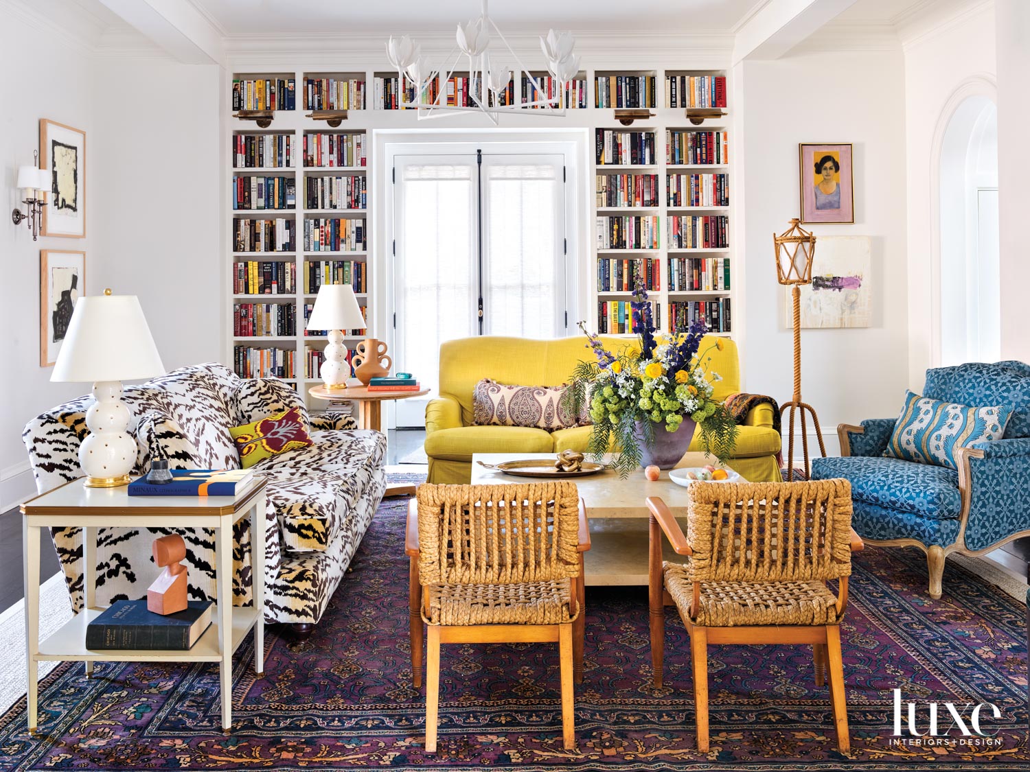 A family room with a mix of patterns and colors including a yellow couch, a tiger print couch and a blue patterned armchair.