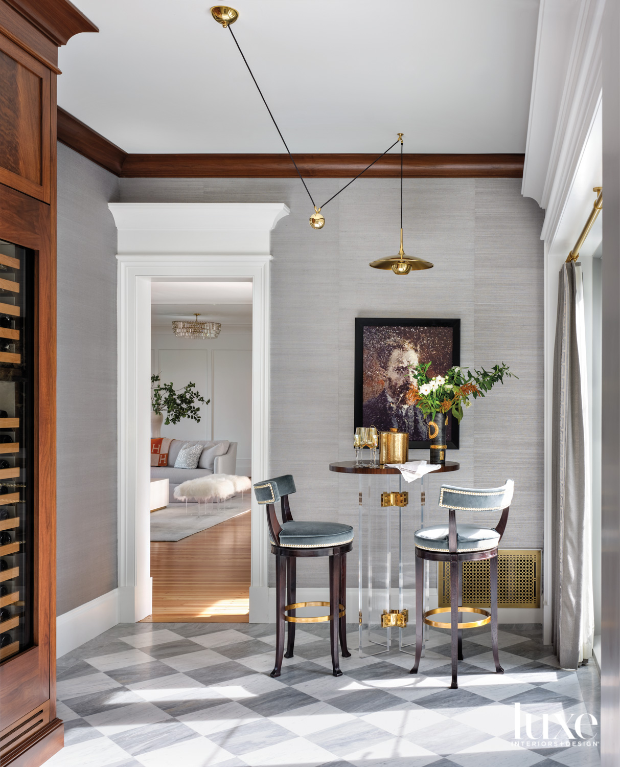 wine room with gray wallcovering, tall bar table, bar stools and sculptural lighting pendant