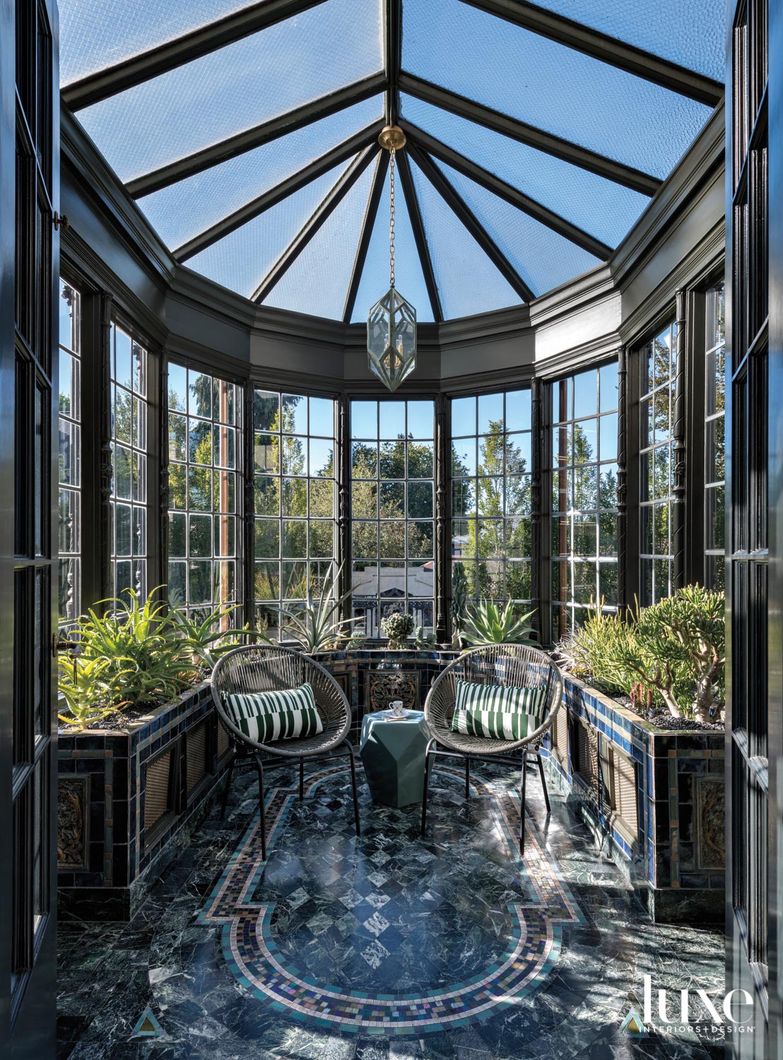 Orangerie with glass ceiling, pendant light and pair of chairs