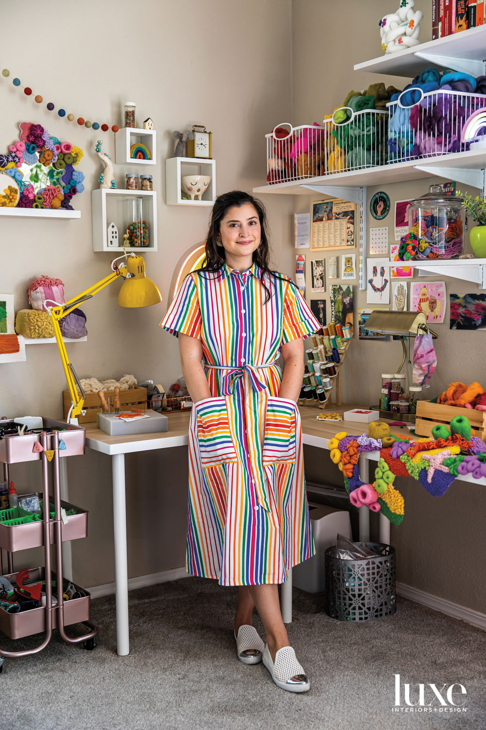 artist felicis murray stands in her studio surrounded by multi-colored yarns