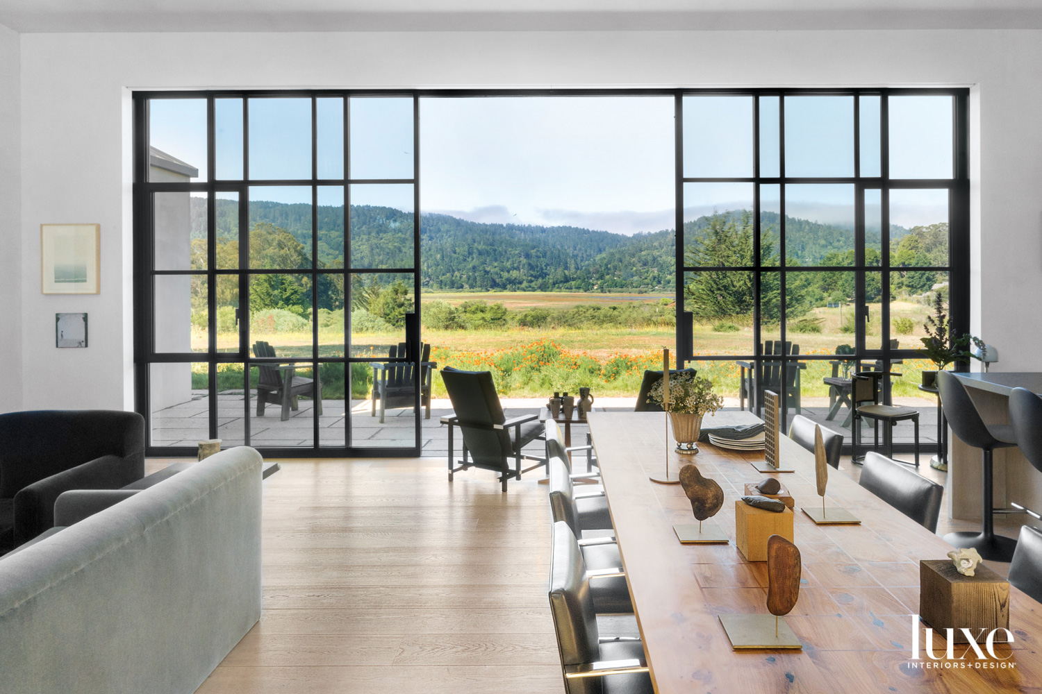 Large metal doors open the living and dining areas to the lush landscape.